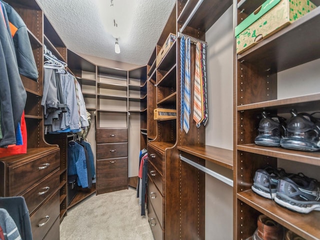 walk in closet featuring light colored carpet