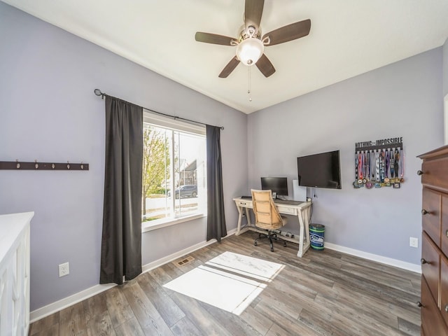 office area with baseboards, a ceiling fan, visible vents, and wood finished floors