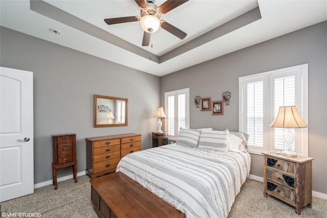 4522 145th St, Urbandale, IA 50323 - bedroom featuring baseboards, light carpet, a tray ceiling, and ceiling fan