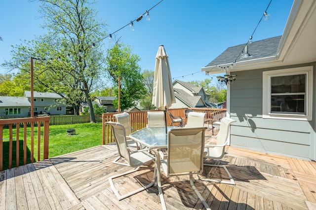 wooden deck featuring a yard, fence, and outdoor dining space