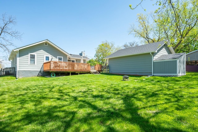rear view of house featuring a lawn, a storage shed, an outdoor structure, and a wooden deck