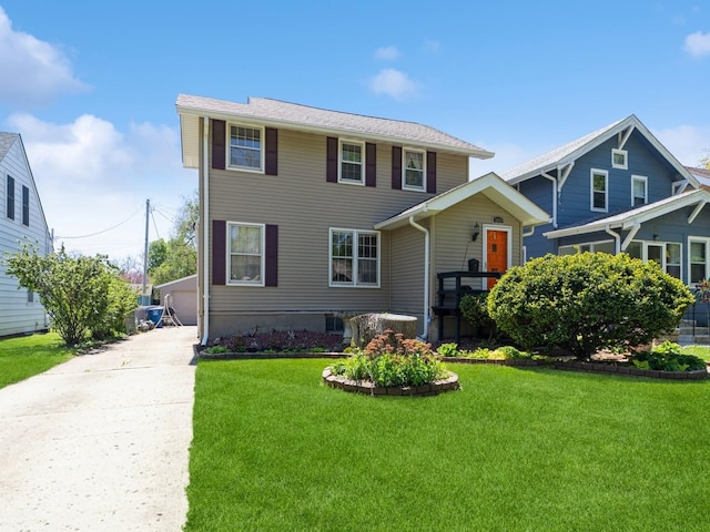view of front of home with a front lawn, an outbuilding, and a detached garage