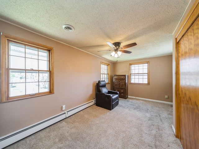 sitting room featuring a textured ceiling, a baseboard radiator, ceiling fan, carpet flooring, and baseboards