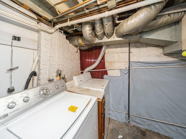 washroom with washer and clothes dryer, laundry area, and concrete block wall
