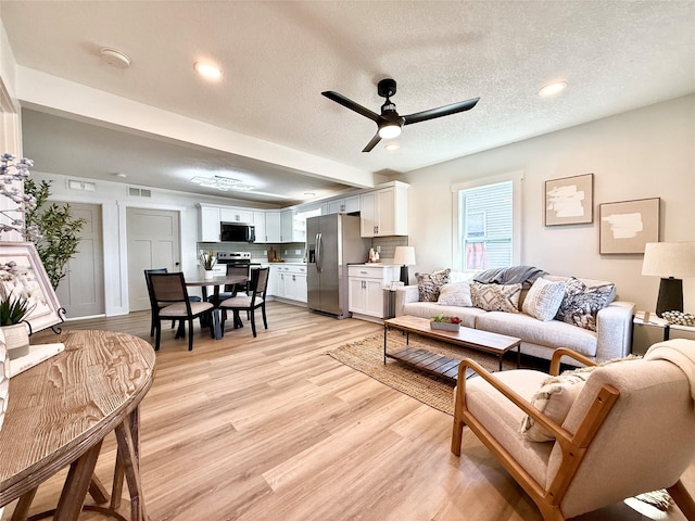 living area featuring recessed lighting, a textured ceiling, visible vents, ceiling fan, and light wood-type flooring