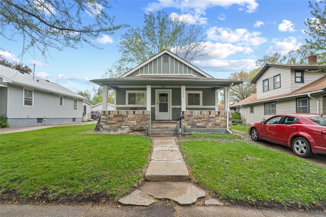 view of front of home featuring a front lawn, board and batten siding, and covered porch