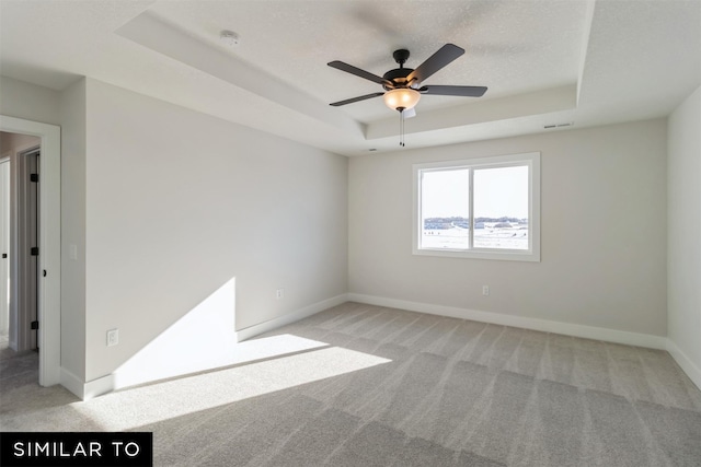 4112 NE 5th St, Ankeny, IA 50021 - spare room featuring a tray ceiling, ceiling fan, and light colored carpet