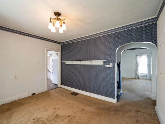 325 W 8th St S, Newton, IA 50208 - unfurnished room featuring carpet flooring, arched walkways, ornamental molding, baseboards, and a chandelier
