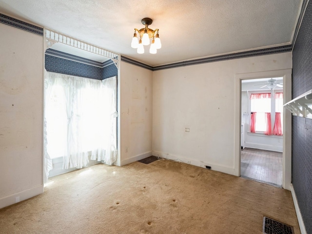 325 W 8th St S, Newton, IA 50208 - carpeted empty room featuring a chandelier, ornamental molding, a textured ceiling, and baseboards