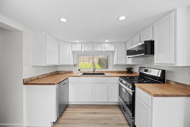 905 E 8th St S, Newton, IA 50208 - kitchen with appliances with stainless steel finishes, a sink, wood counters, recessed lighting, and white cabinets