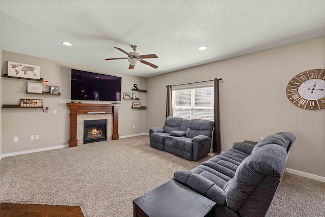 270 NE Prairie Wolf Dr, Waukee, IA 50263 - carpeted living area featuring a ceiling fan, a tiled fireplace, recessed lighting, baseboards, and a textured ceiling