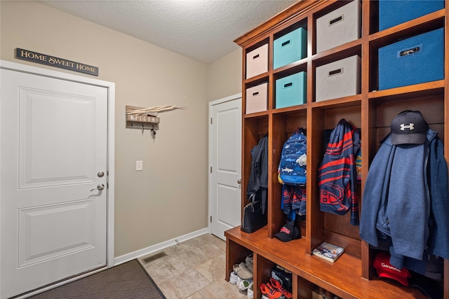 270 NE Prairie Wolf Dr, Waukee, IA 50263 - mudroom featuring a textured ceiling and baseboards