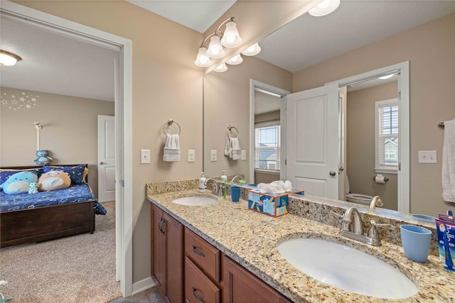 270 NE Prairie Wolf Dr, Waukee, IA 50263 - ensuite bathroom with double vanity, plenty of natural light, toilet, and baseboards