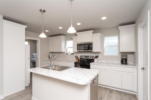 kitchen featuring a sink, white cabinetry, stainless steel appliances, a kitchen island with sink, and light wood-type flooring