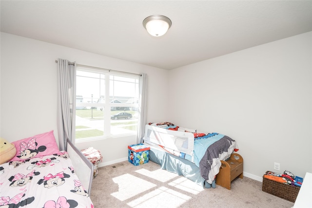 carpeted bedroom featuring baseboards and visible vents