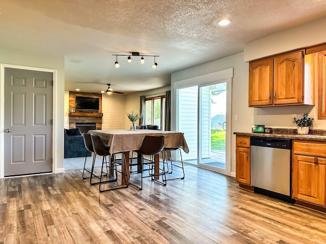 917 SE Allyn St, Ankeny, IA 50021 - kitchen featuring a textured ceiling, stainless steel dishwasher, light wood-style flooring, and brown cabinetry
