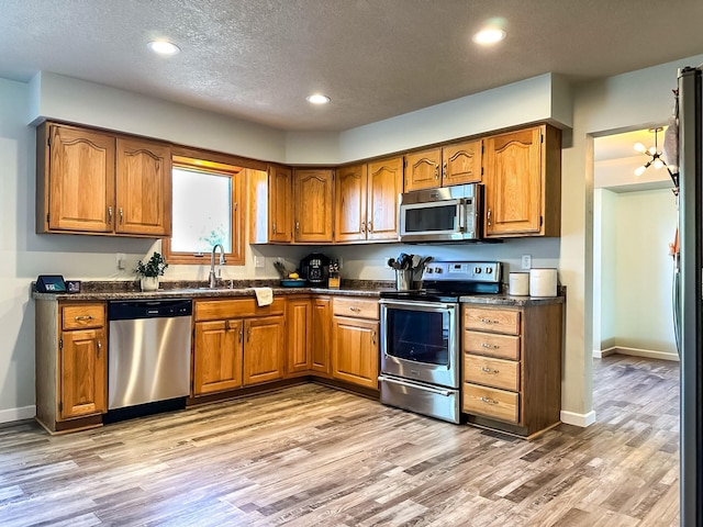 917 SE Allyn St, Ankeny, IA 50021 - kitchen featuring dark countertops, stainless steel appliances, and brown cabinetry