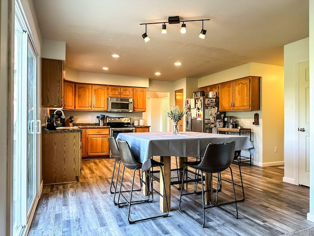917 SE Allyn St, Ankeny, IA 50021 - kitchen featuring dark countertops, stainless steel appliances, brown cabinetry, and recessed lighting