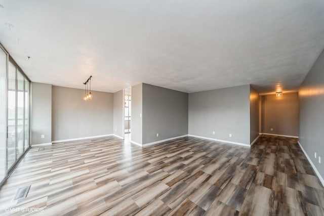 unfurnished room featuring wood finished floors and baseboards