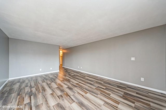 spare room featuring wood finished floors and baseboards