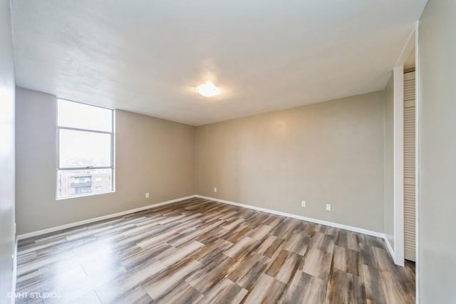 empty room featuring baseboards and wood finished floors