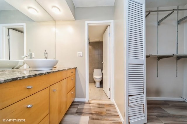 bathroom with vanity, toilet, and baseboards