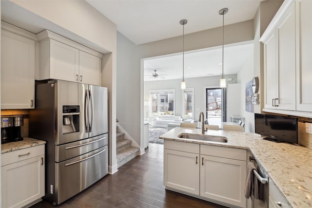118 E Center St, Des Moines, IA 50309 - kitchen featuring appliances with stainless steel finishes, a sink, a peninsula, dark wood-style floors, and decorative backsplash