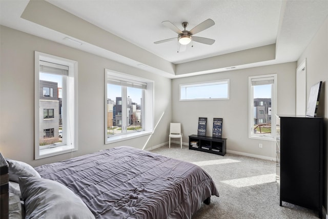 bedroom featuring carpet flooring, a ceiling fan, baseboards, and a raised ceiling