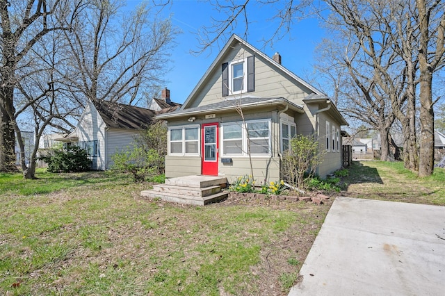 bungalow featuring a chimney and a front yard