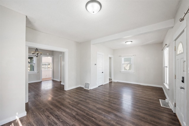 entryway featuring dark wood-style flooring, a notable chandelier, and visible vents