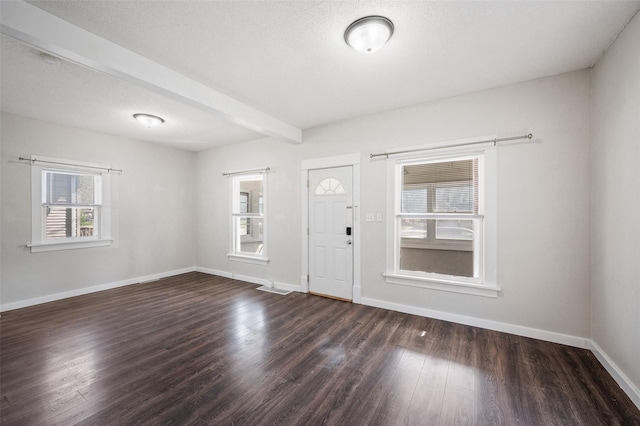 entryway featuring beam ceiling, baseboards, and wood finished floors