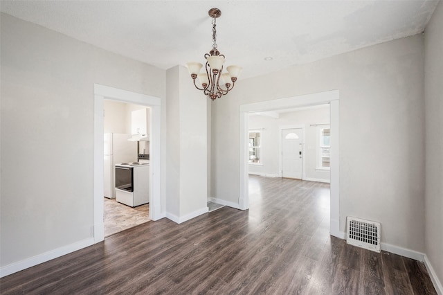 unfurnished dining area with a chandelier, visible vents, dark wood-style flooring, and baseboards