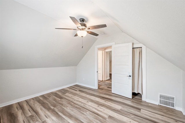 bonus room featuring a ceiling fan, baseboards, visible vents, vaulted ceiling, and light wood-type flooring