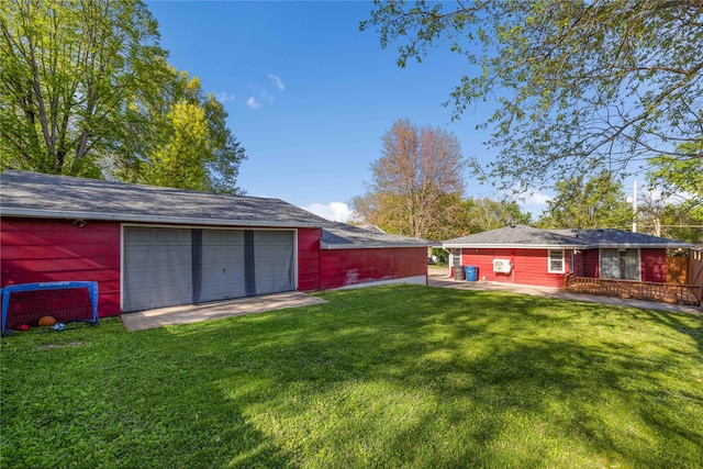 view of yard with driveway, an outbuilding, and a detached garage