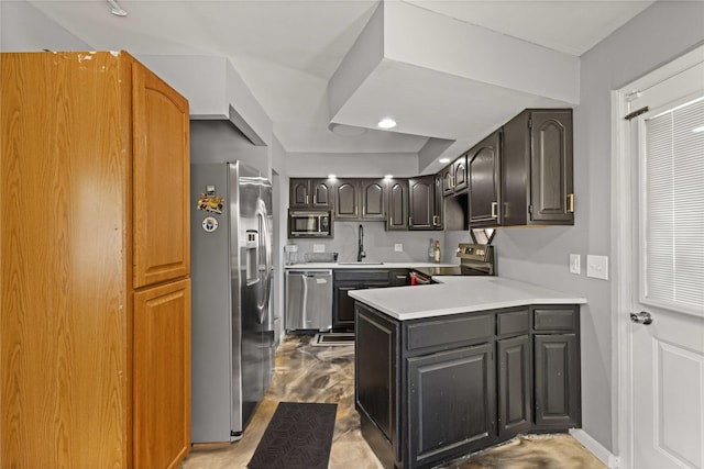 kitchen with a peninsula, light countertops, stainless steel appliances, and a sink
