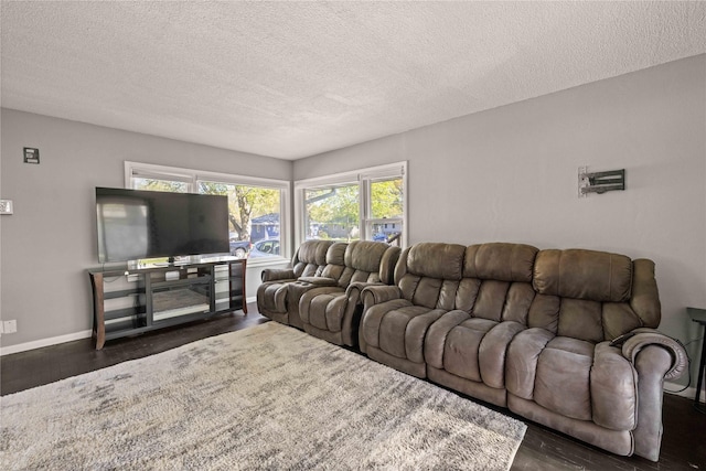 living area featuring a textured ceiling, baseboards, and dark wood finished floors