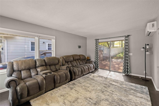 living area featuring a textured ceiling, baseboards, wood finished floors, and a wall mounted AC