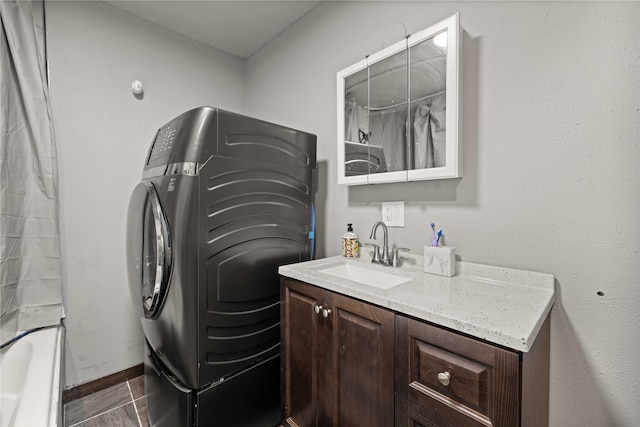 clothes washing area featuring laundry area, washer / clothes dryer, and a sink
