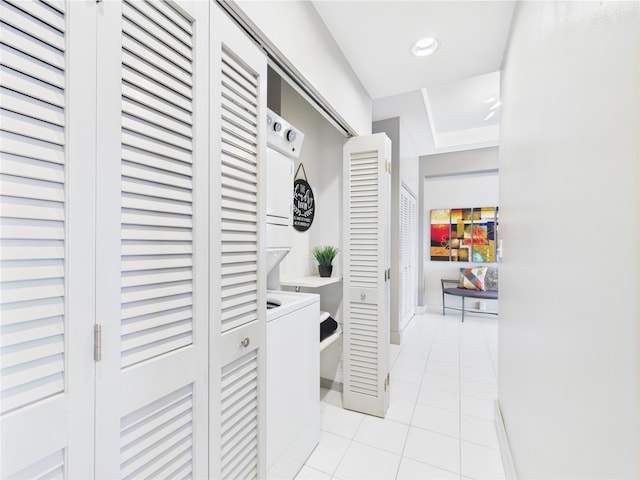 washroom featuring laundry area, stacked washing maching and dryer, baseboards, light tile patterned flooring, and recessed lighting