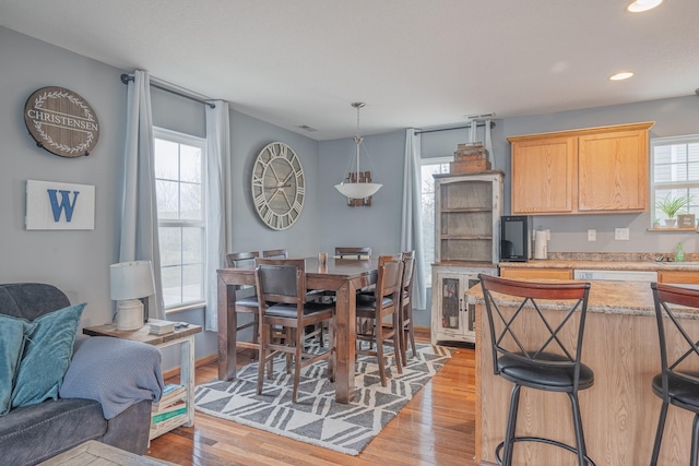 kitchen with a wealth of natural light, light wood finished floors, open floor plan, and recessed lighting