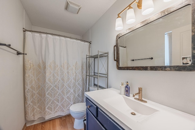 full bath featuring toilet, wood finished floors, a shower with curtain, visible vents, and vanity