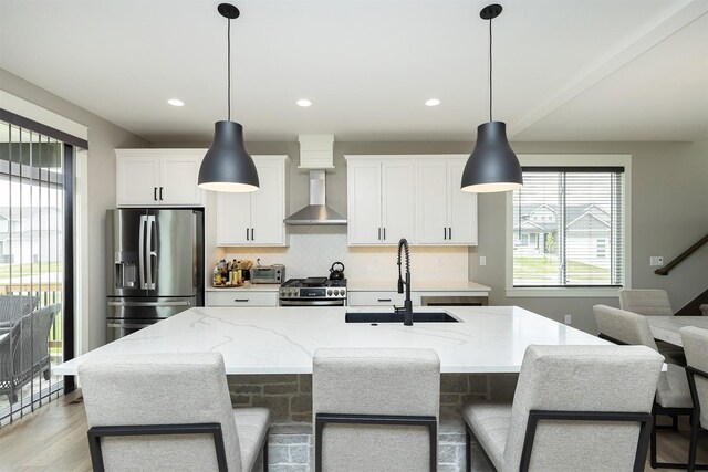 730 NE Country Meadow Dr, Ankeny, IA 50021 - kitchen featuring stainless steel appliances, wall chimney range hood, a sink, white cabinets, and decorative backsplash