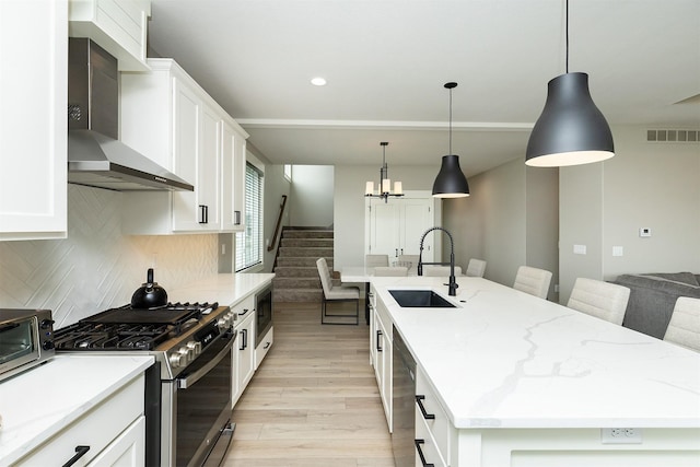730 NE Country Meadow Dr, Ankeny, IA 50021 - kitchen with wall chimney exhaust hood, stainless steel appliances, a sink, an island with sink, and light wood-style flooring