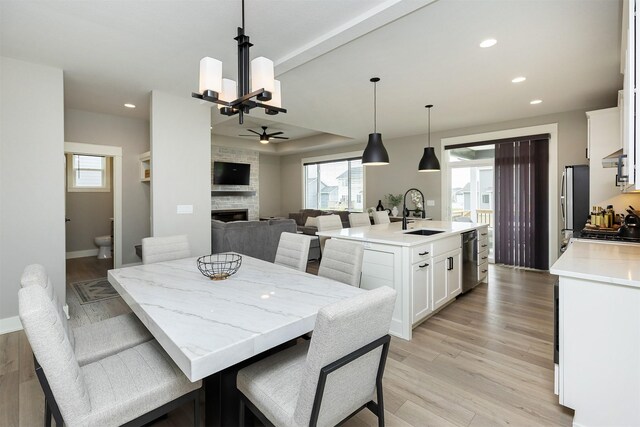 730 NE Country Meadow Dr, Ankeny, IA 50021 - dining room with a stone fireplace, recessed lighting, a chandelier, ceiling fan, and light wood finished floors
