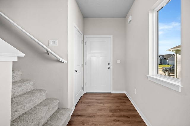 doorway to outside featuring stairway, wood finished floors, healthy amount of natural light, and baseboards