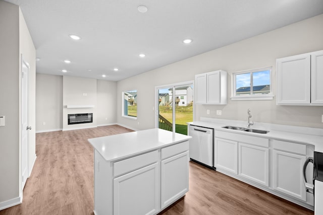 kitchen featuring a sink, dishwasher, recessed lighting, a center island, and white cabinets