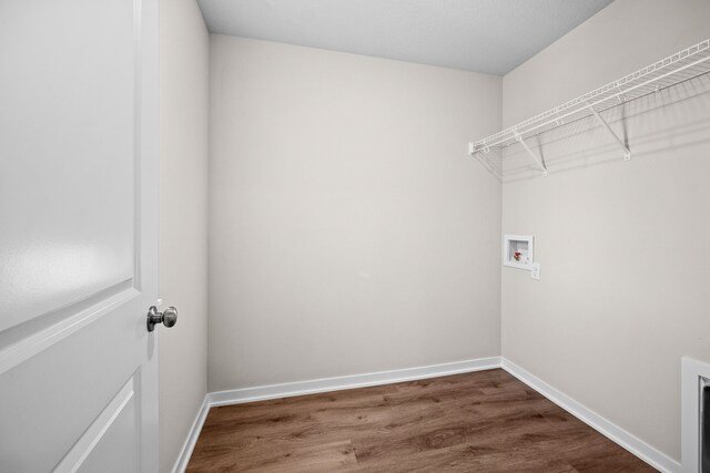 washroom featuring washer hookup, dark wood finished floors, and baseboards