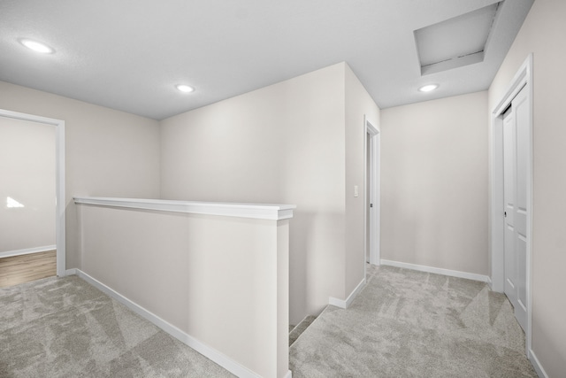 hall featuring an upstairs landing, carpet flooring, attic access, recessed lighting, and baseboards