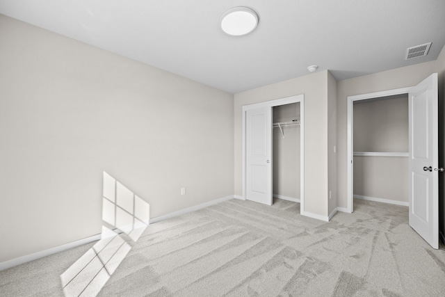 unfurnished bedroom featuring light carpet, a closet, and baseboards