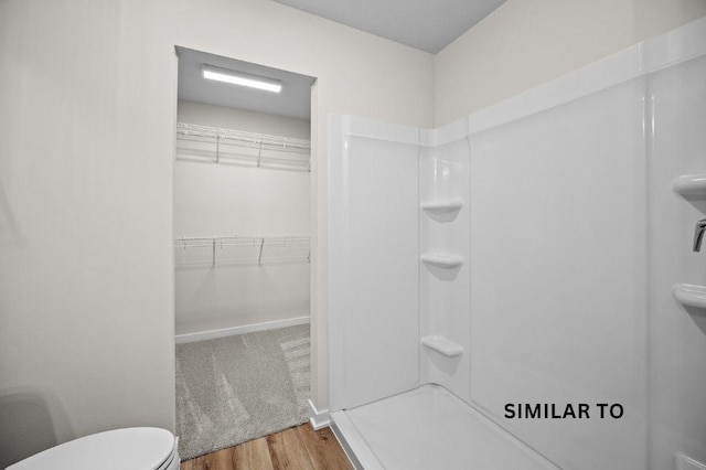 4404 Honey Bee Rdg, Des Moines, IA 50317 - bathroom featuring wood finished floors, a shower, toilet, and a walk in closet